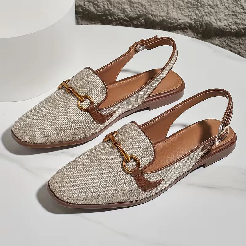 Flat sandal with metallic buckle fastening