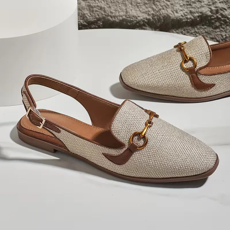 Flat sandal with metallic buckle fastening
