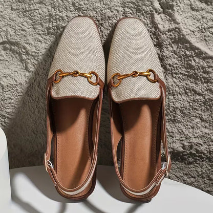 Flat sandal with metallic buckle fastening